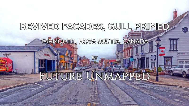 Seasoned road - where parked vehicles serve as target practice for circling gulls - flanked by revitalized building exteriors and Canada flags with rotated maple leafs.
